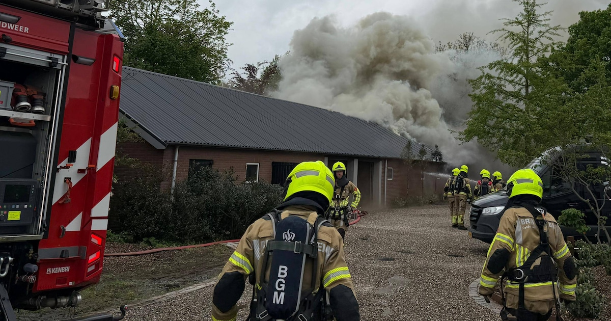 Brandweer nog geruime tijd bezig met brand in schuur, deel van gebouw dreigt in te storten