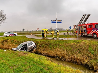 Auto vliegt over rotonde en rijdt verkeersbord omver, één gewonde is er mogelijk slecht aan toe