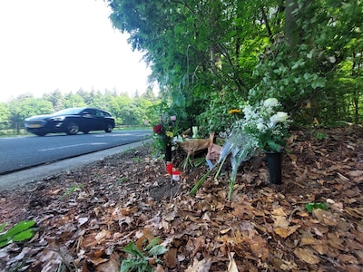 Bloemen en brokstukken langs de weg herinneren aan dodelijk ongeval automobilist en motorrijder