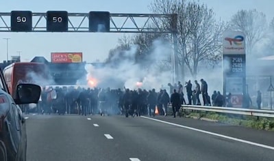Gemaskerde hooligans lopen met  fakkels over A4, spelersbus Ajax beschadigd: ‘Dit kan niet’