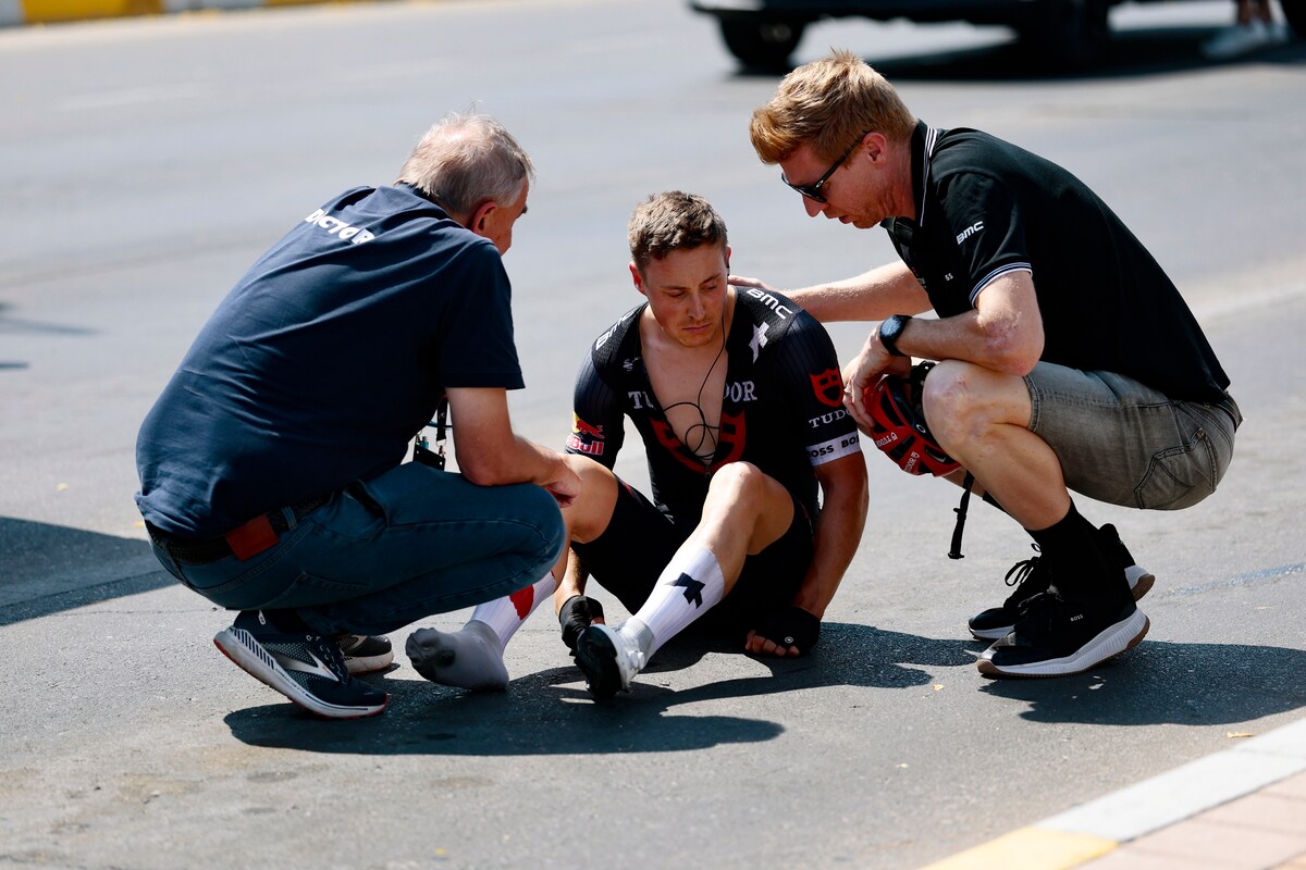Arvid de Kleijn zit aangeslagen op het asfalt na een zware val in de UAE Tour.