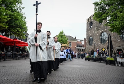 Winkelend publiek kijkt verbaasd naar religieuze stoet: ‘Wat