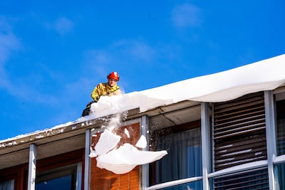 Telefoon roodgloeiend bij dakdekkers, smeltende sneeuw sijpelt naar binnen