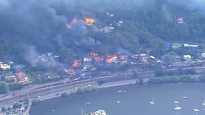 Bosbranden leggen tientallen huizen in de as ten noorden van Sydney, duizenden bewoners geëvacueerd
