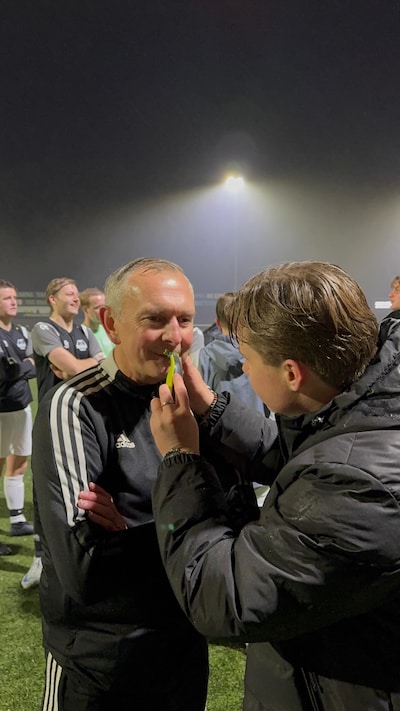 Vrienden tegenover elkaar op het veld met snor in benefietwedstrijd