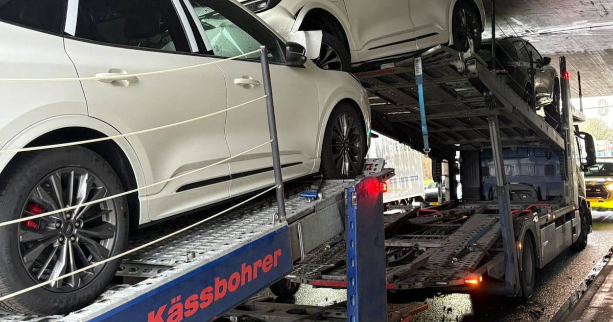 Vrachtwagen met lading gloednieuwe auto’s vast onder viaduct van de A12