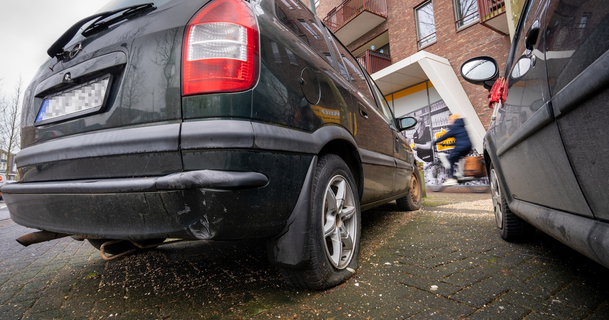 Een auto die al maanden op dezelfde plek geparkeerd staat en onder het ...