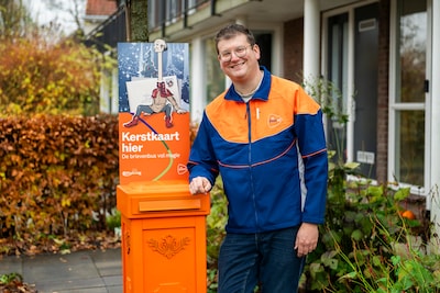 PostNL komt met speciale kerstbrievenbussen, bij een postbezorger in de tuin