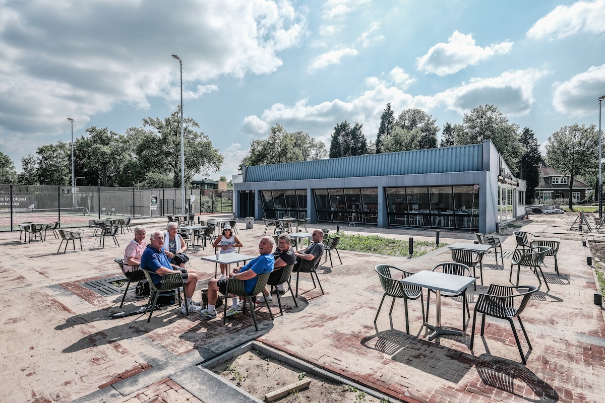 ,,Kijk eens hoe mooi we hier zitten met zicht op alle banen”, zegt het clubje zestigplussers op het nieuwe terras.