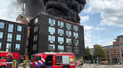 Grote brand bij voormalig kantoorpand in Maastricht, rookpluim tot ver buiten de stad zichtbaar