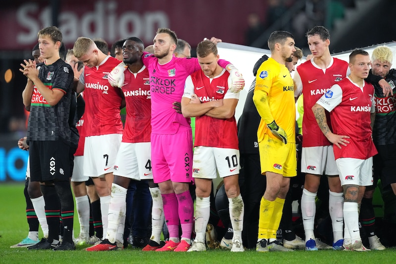 De spelers van NEC en AZ hopen op een goede afloop als Bas Dost wordt behandeld, nadat hij in elkaar is gezakt op het veld.