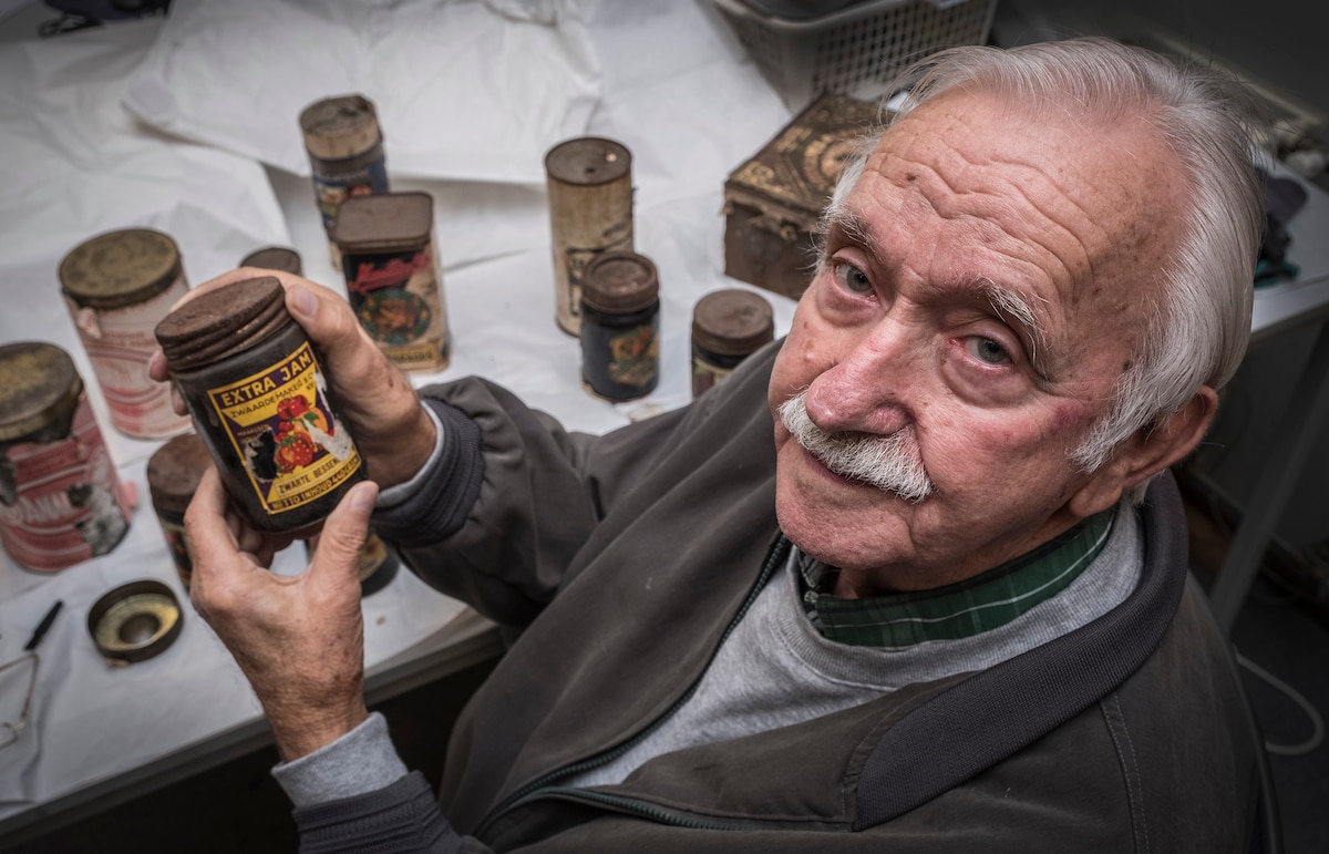 Thijs van Woerkom op 84-jarige leeftijd in 2018, met blikken jam uit de Tweede Wereldoorlog. 
