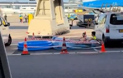 Opvallende beelden op Schiphol: medewerkers zoeken verkoeling in kinderbadje tussen vliegtuigen