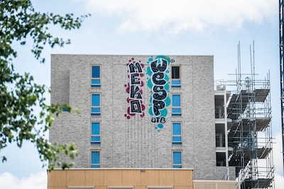 Twee reusachtige tags op de muur van een woontoren zijn van verre te zien: ‘Dit is een enorme schade