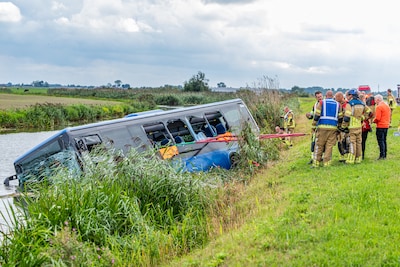 Lijnbus belandt in sloot na ernstig ongeluk met motorrijder in Friesland, meerdere gewonden