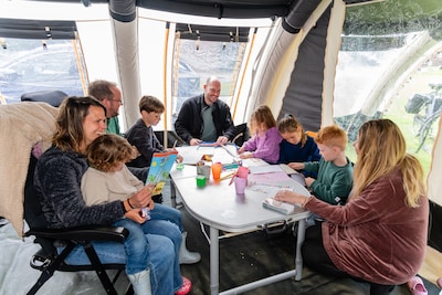 Stapel spelletjes en een dikke trui doen wonderen: deze kampeerders laten zich niet afschrikken door een spatje regen