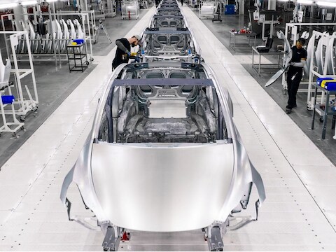 De productie van auto's in een Tesla-fabriek. Hoe kan het dat de fabrikant keer op keer zijn prijzen verlaagt?