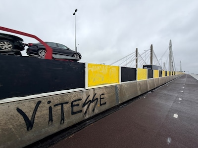Gloednieuwe schermen van belangrijke snelwegbrug over lengte van een kilometer beklad met geel-zwarte verf