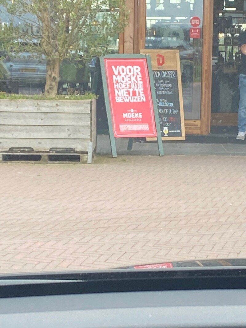 De borden voor de ingang van Moeke, waar de gemeente Nijmegen naar verwijst. Hierop maakt het restaurant duidelijk de coronatoegangscheck niet al te streng te hanteren.