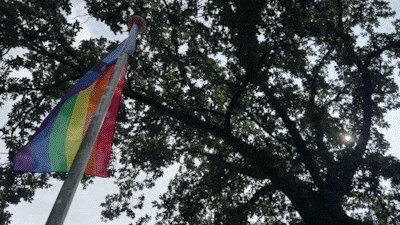 Jan (84) hangt zijn regenboogvlag vast met tiewraps. En zet er een bordje bij voor de dief