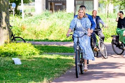Máxima pakt sportief de fiets voor werkbezoek aan Amsterdam