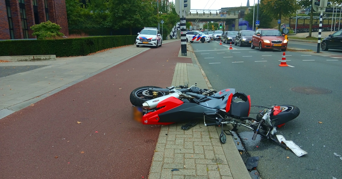Voorwiel motor breekt af door klap bij ongeval, weg deels afgesloten.