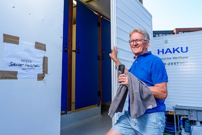 Met toilettas en handdoek onder de arm naar buiten: Bas doucht al weken noodgedwongen op parkeerplaats